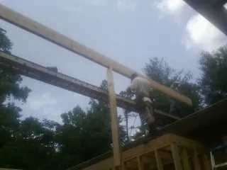 Carpenter setting a ridge beam over a new addition frame — Ice Dam Removal by Roofing Brothers in Cream Ridge