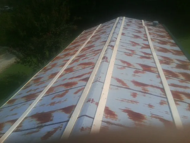 Rusted metal roof panels with new wood purlins before replacement — Storm Damage Roof Repair in Cream Ridge by Roofing Brothers