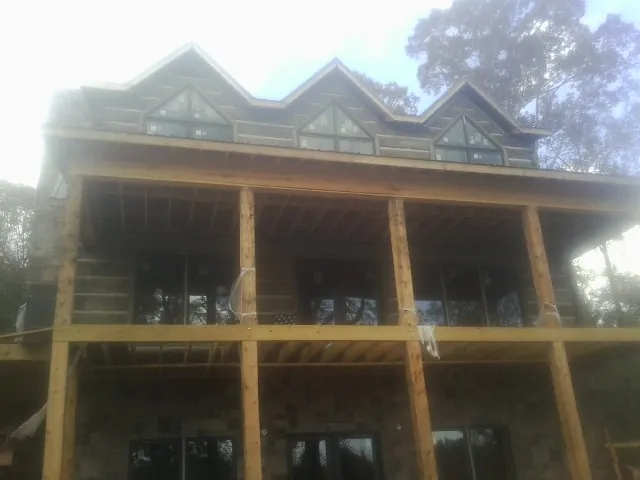 Dormers and porch framing on a large log home under construction — Roof Coating work by our crew in Cream Ridge