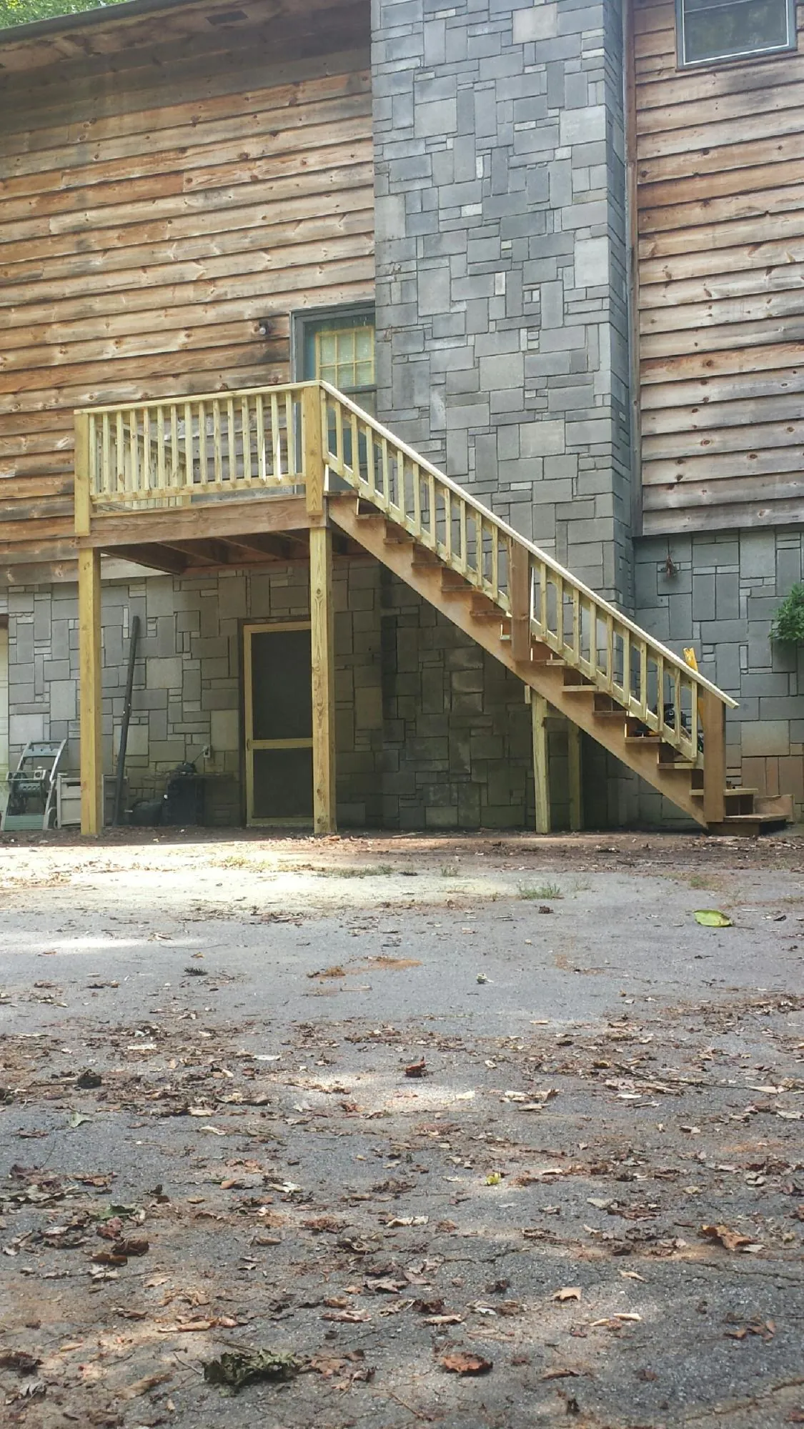New pressure treated deck and stair landing on a log home in Cream Ridge