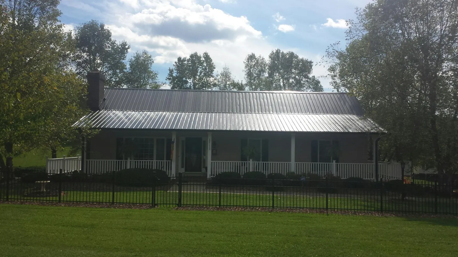 Gray metal roof on a brick ranch with a full width front porch — Gutter Guard Installation work by our crew in Cream Ridge