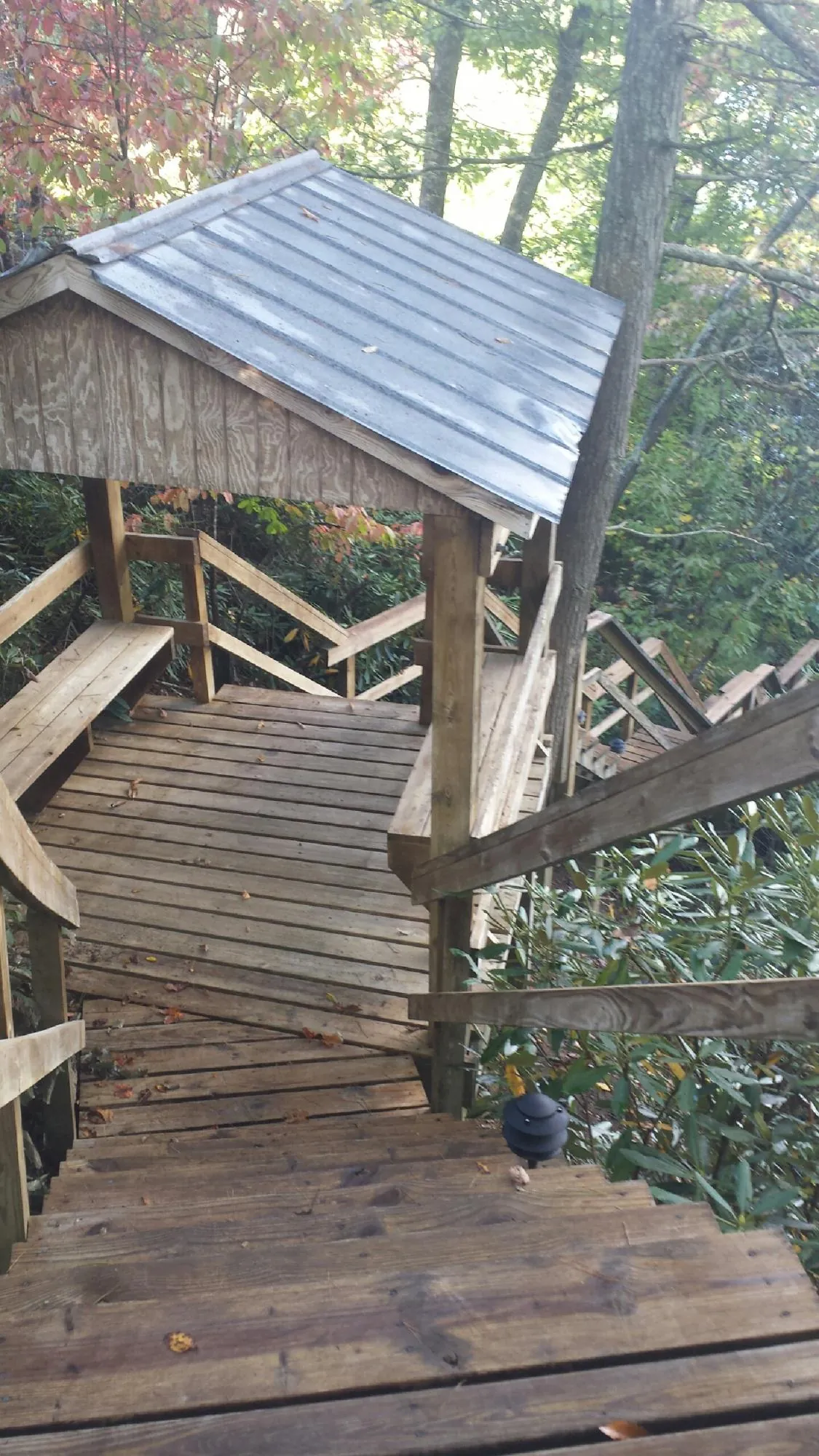 Metal roofed shelter over wooden steps on a wooded walkway — Skylight Repair & Installation work by our crew in Cream Ridge